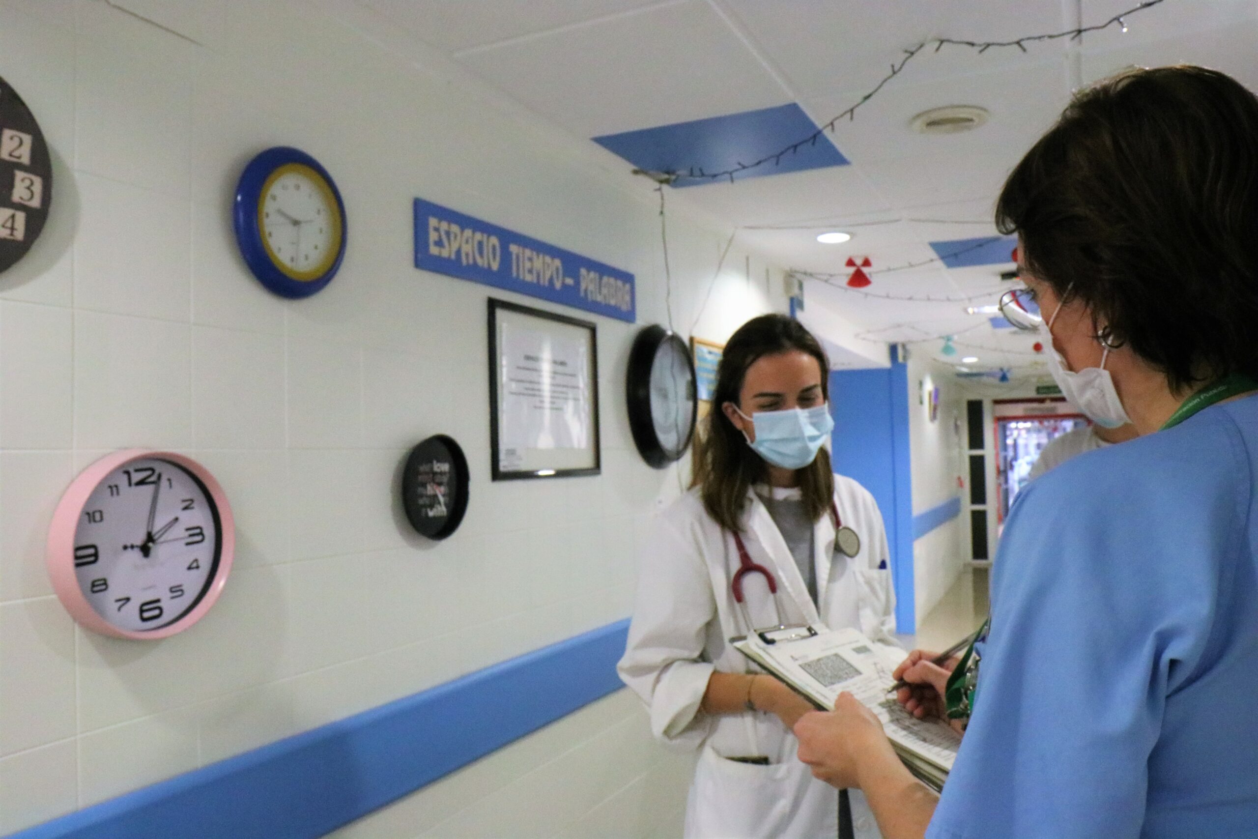 área de palitivos con una enfermera y una médica hablando sobre al tratamiento de un paciente de medicina interna