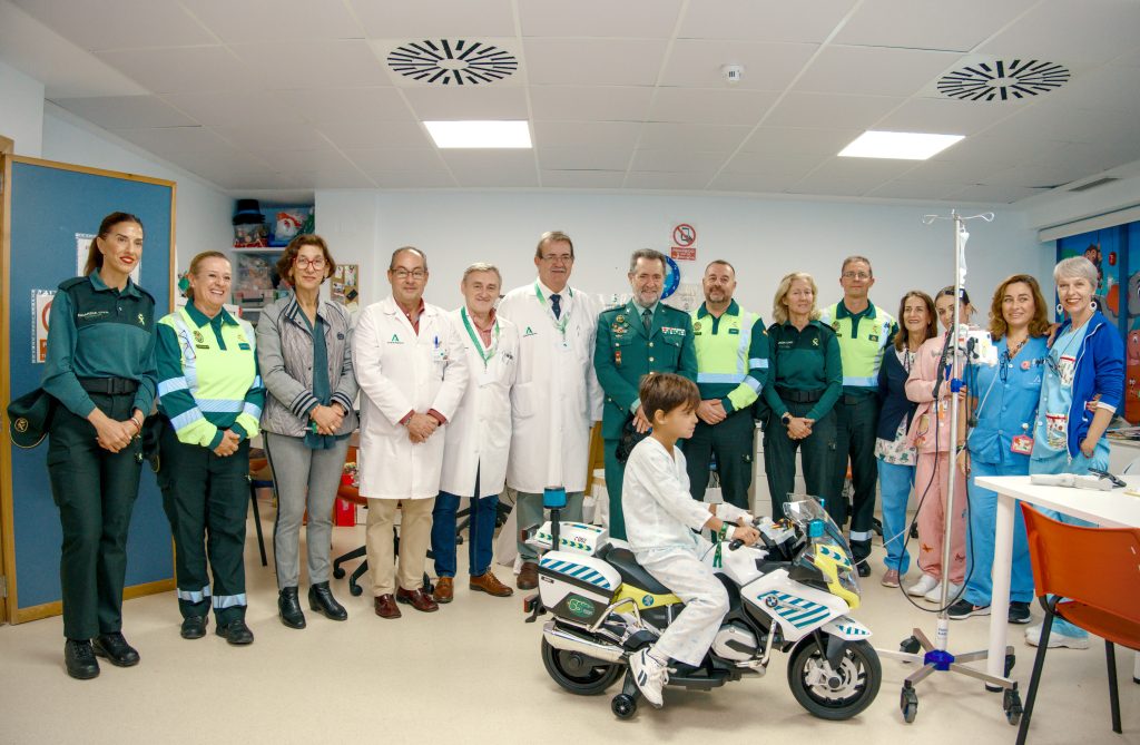 Entrega de una moto de juguete en la Escuela hospitalaria del Hospital Virgen del Rocío, en Sevilla, con motivo del 65 aniversario del destacamento de tráfico de la Guardia Civil